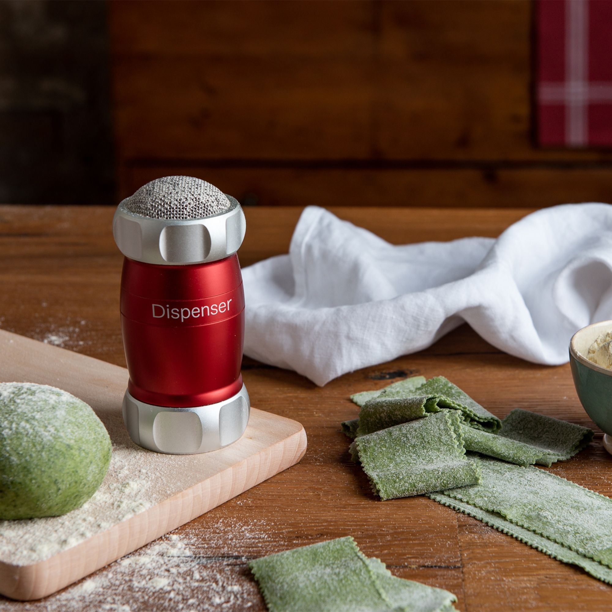 Red flour shaker on board with fresh pasta